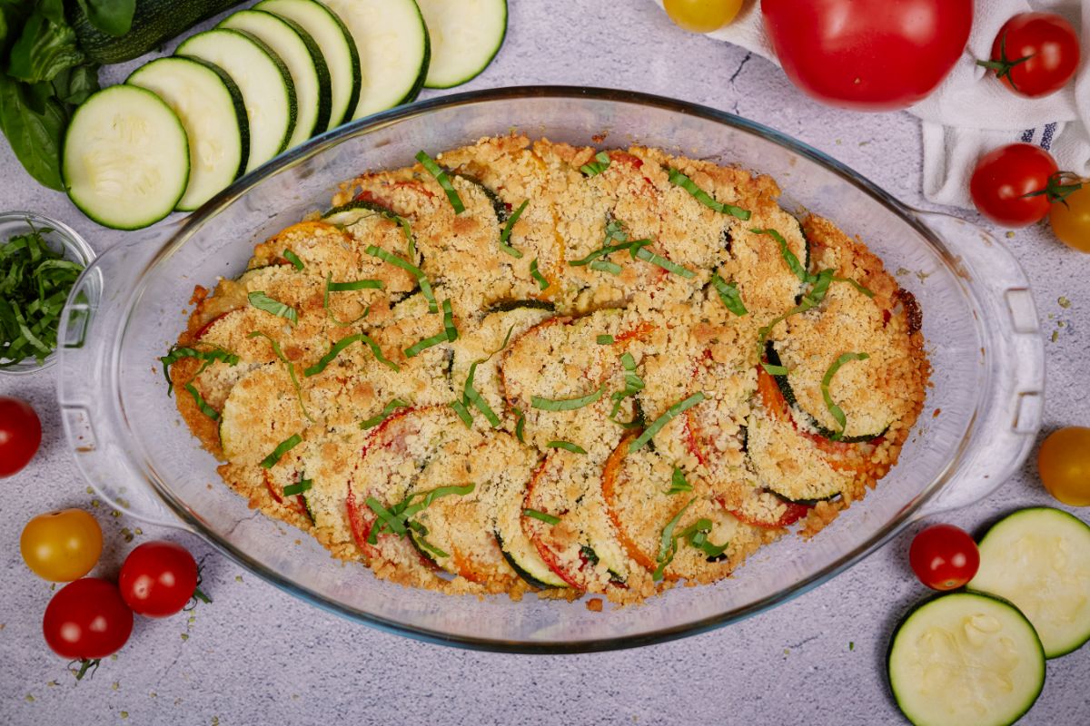 image looking down on oval glass baking dish of zucchini and tomato casserole