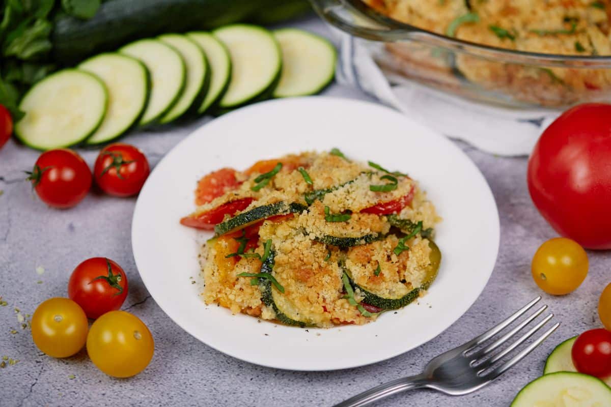 round white bowl of zucchini casserole on gray table