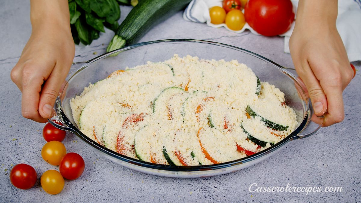 layered vegetables in casserole dish with cheese on top