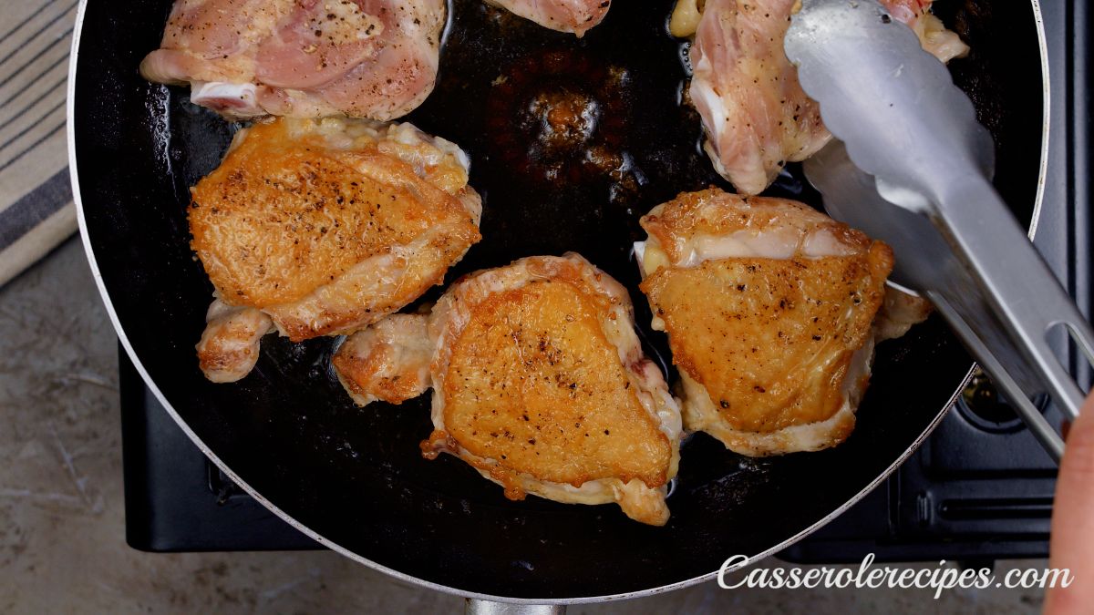 browned skin on chicken thigh in skillet