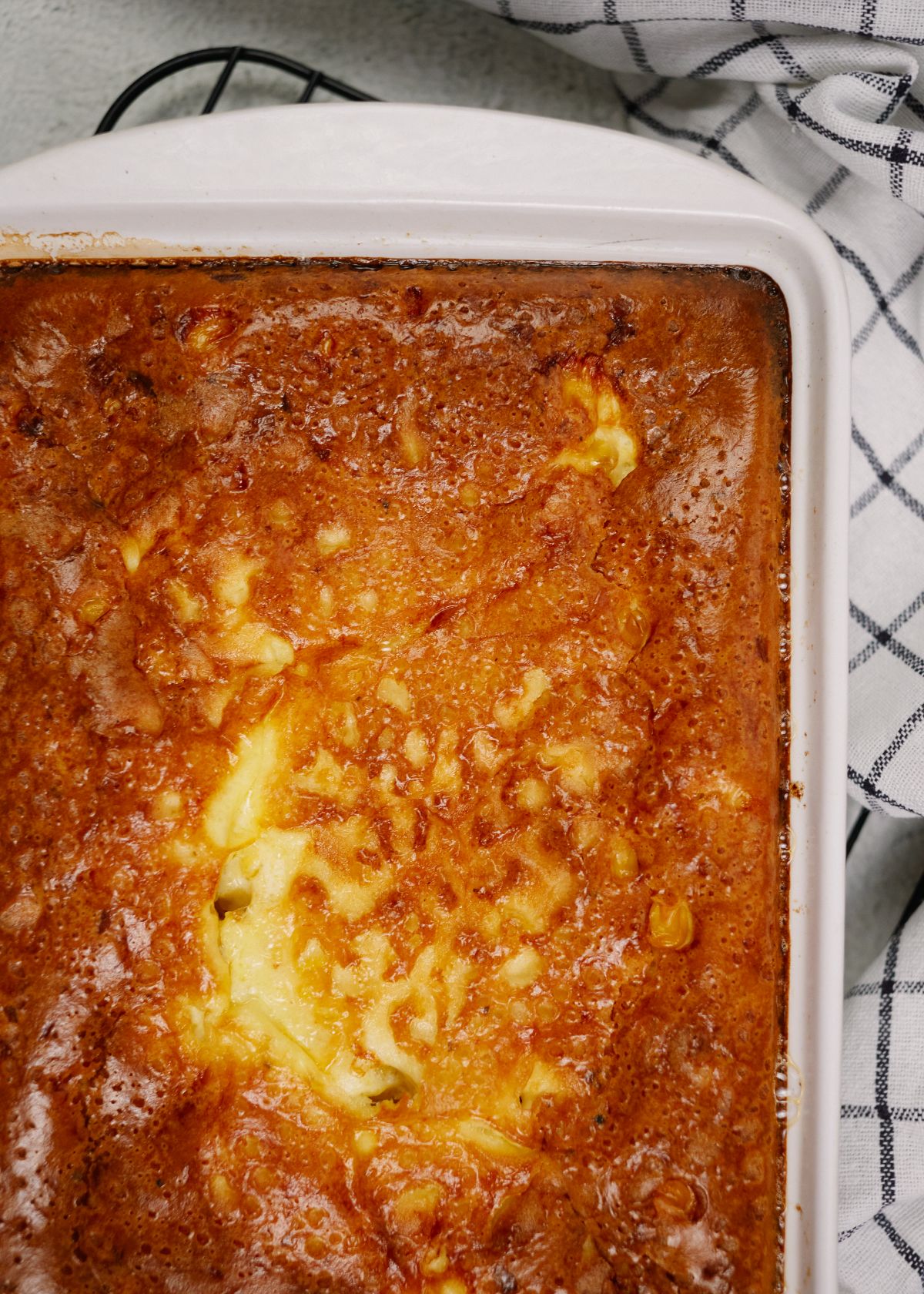 baking dish of corn pudding casserole laying on wire rack