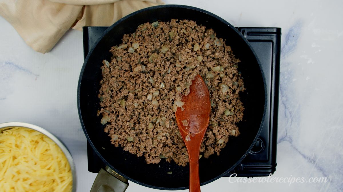cooked ground beef in black skillet on hot plate