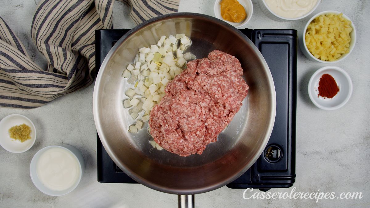 onions and raw ground beef in skillet on hot plate