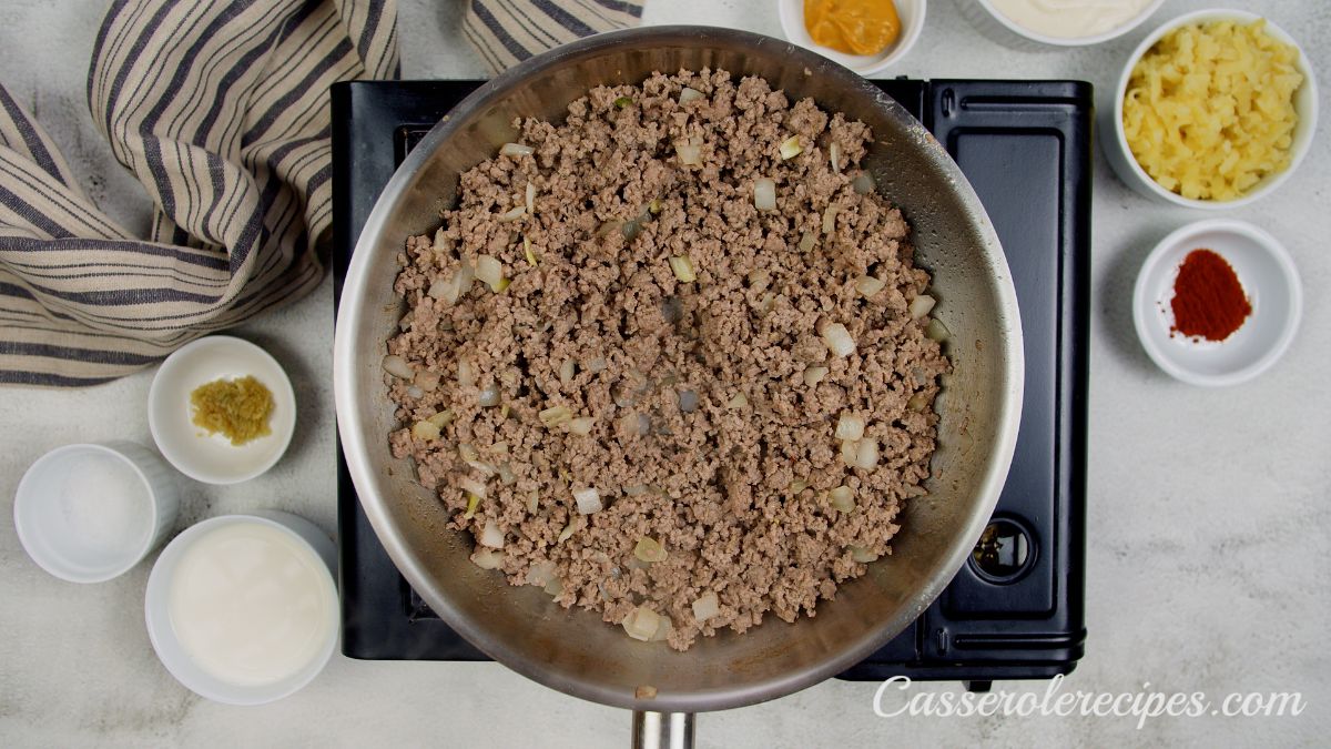 cooked ground beef in stainless steel skillet on hot plate
