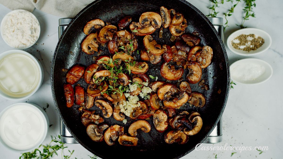 browned mushrooms in skillet with fresh herbs and garlic