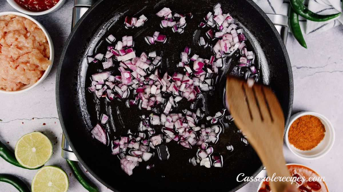 red onions being cooked in black skillet