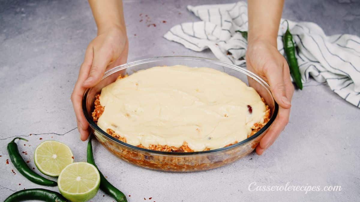glass baking dish of chicken tamale pie being held before baking
