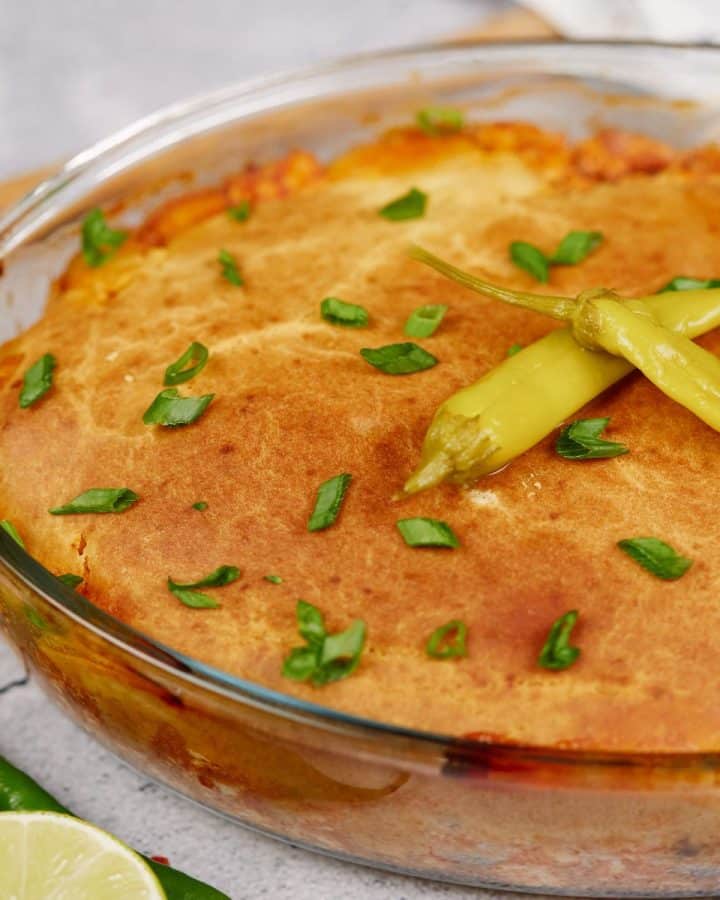 glass baking dish of chicken tamale pie topped with green peppers