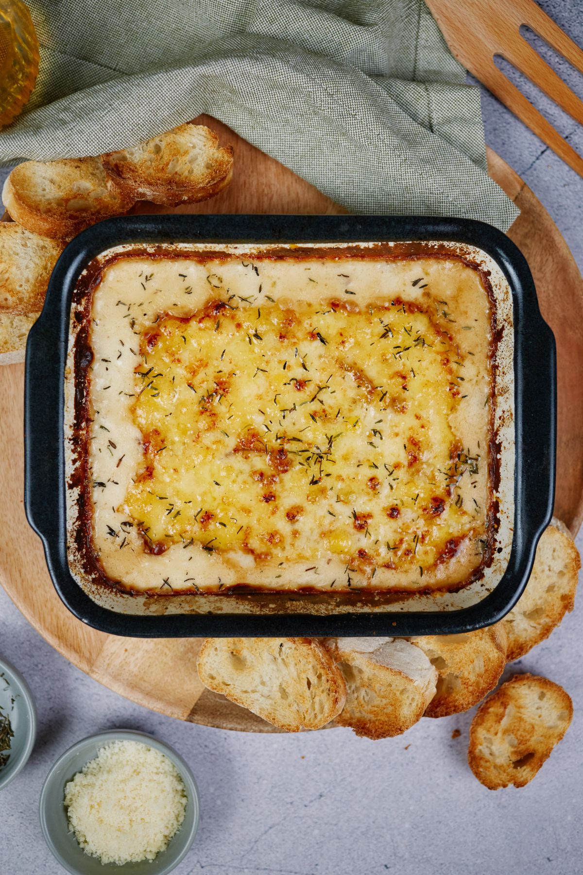 square baking dish with black trim filled with onion gratin