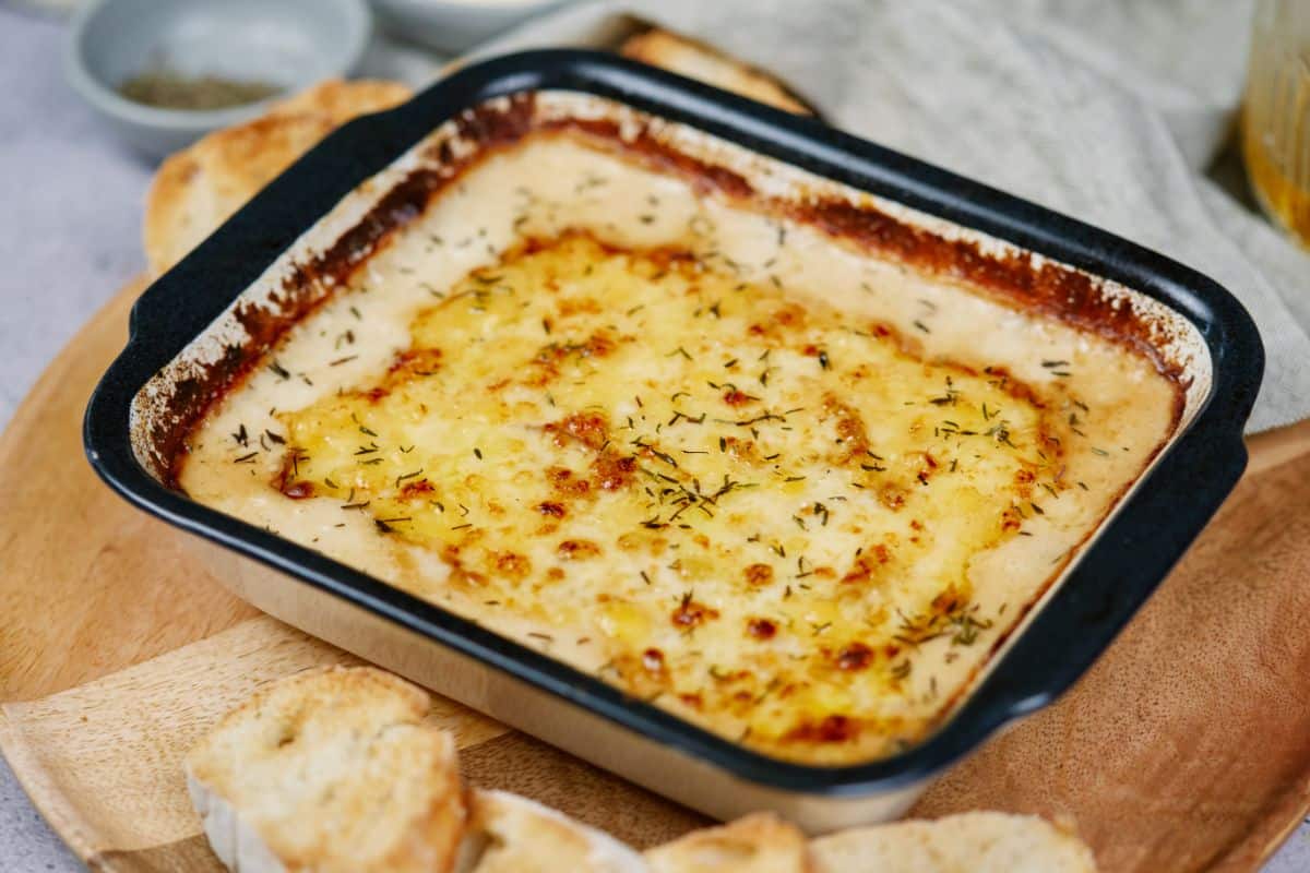 baking dish with black trim filled with creamed onion gratin