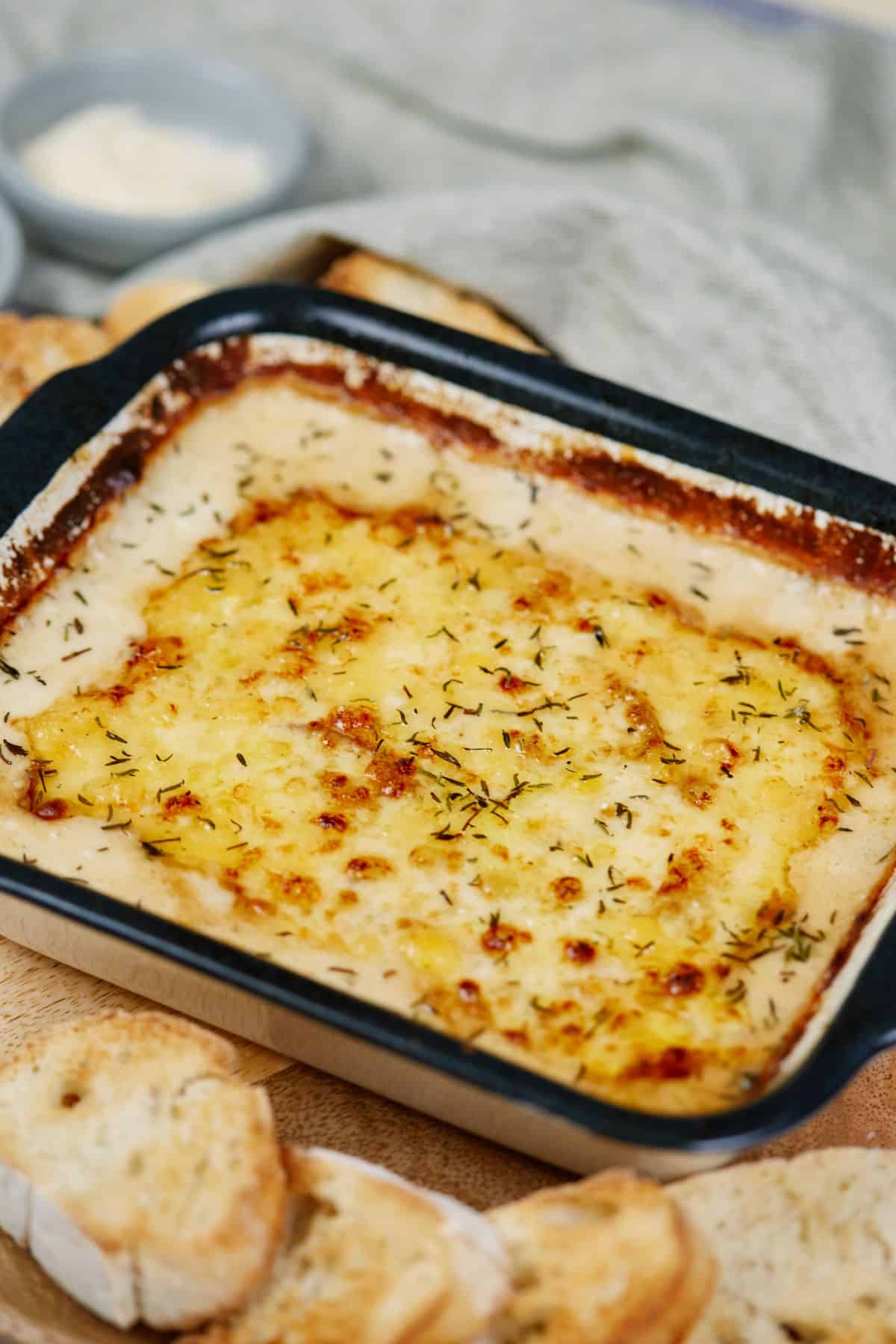 black and white baking dish of creamed onion gratin