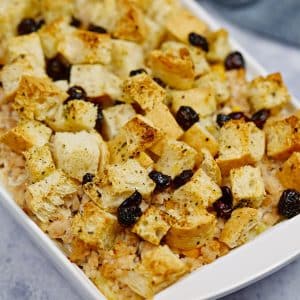 white baking dish of ground turkey casserole topped with croutons and cranberries