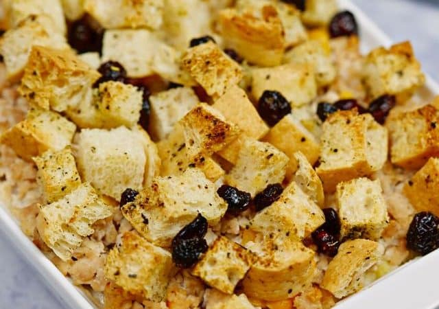 white baking dish of ground turkey casserole topped with croutons and cranberries