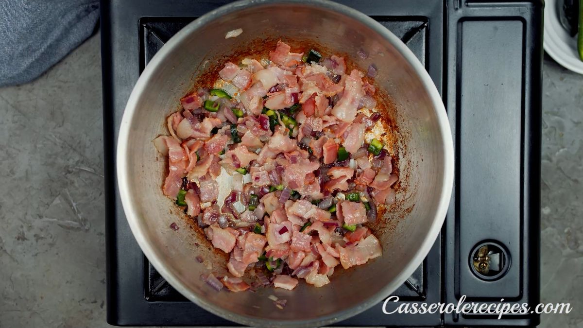 cooked bacon and vegetables in skillet on hot plate