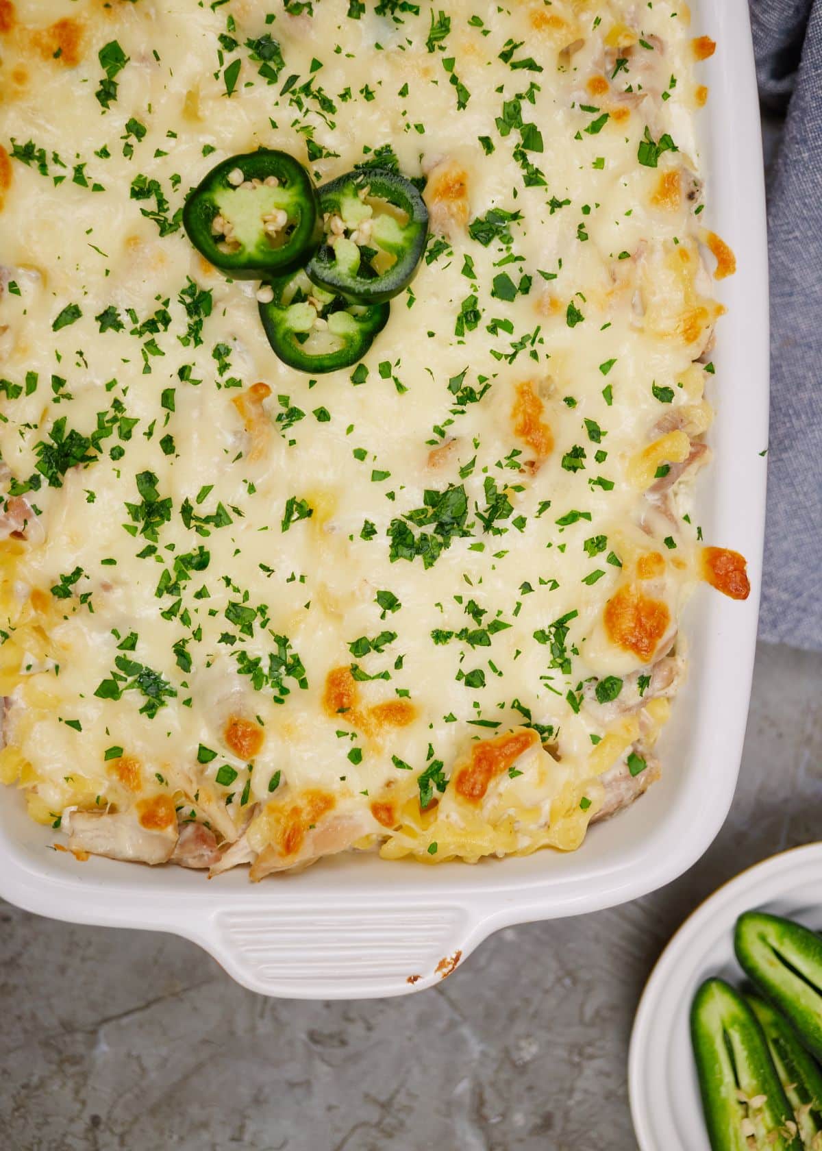 image of red baking dish with white trim filled with jalapeno popper chicken casserole
