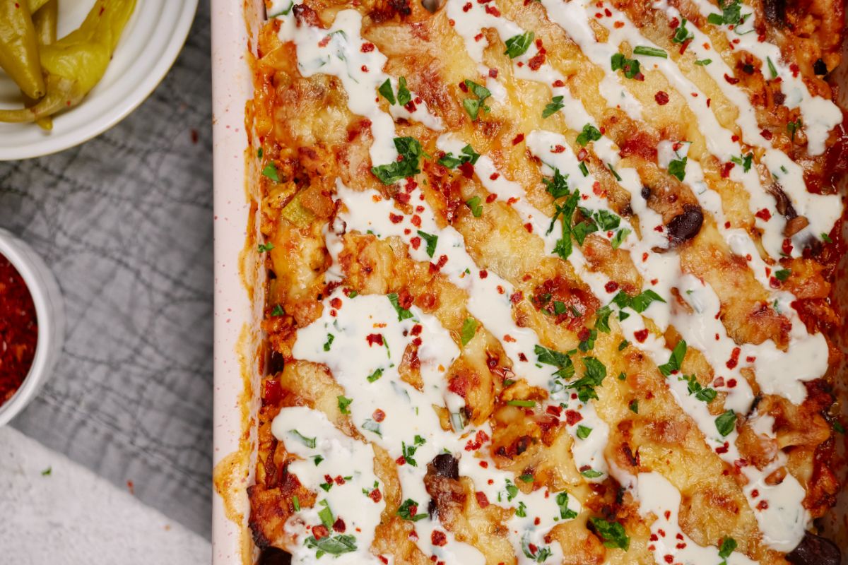 baked mexican casserole topped with sour cream and fresh herbs