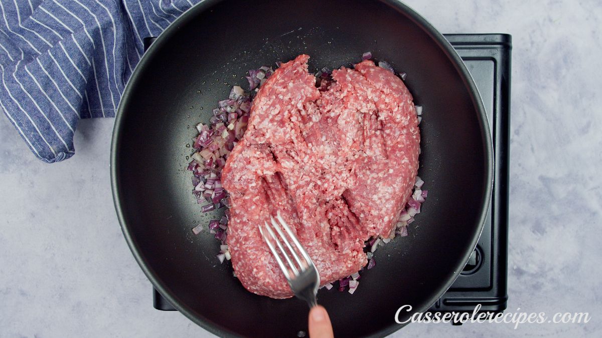 raw ground beef in skillet with fork