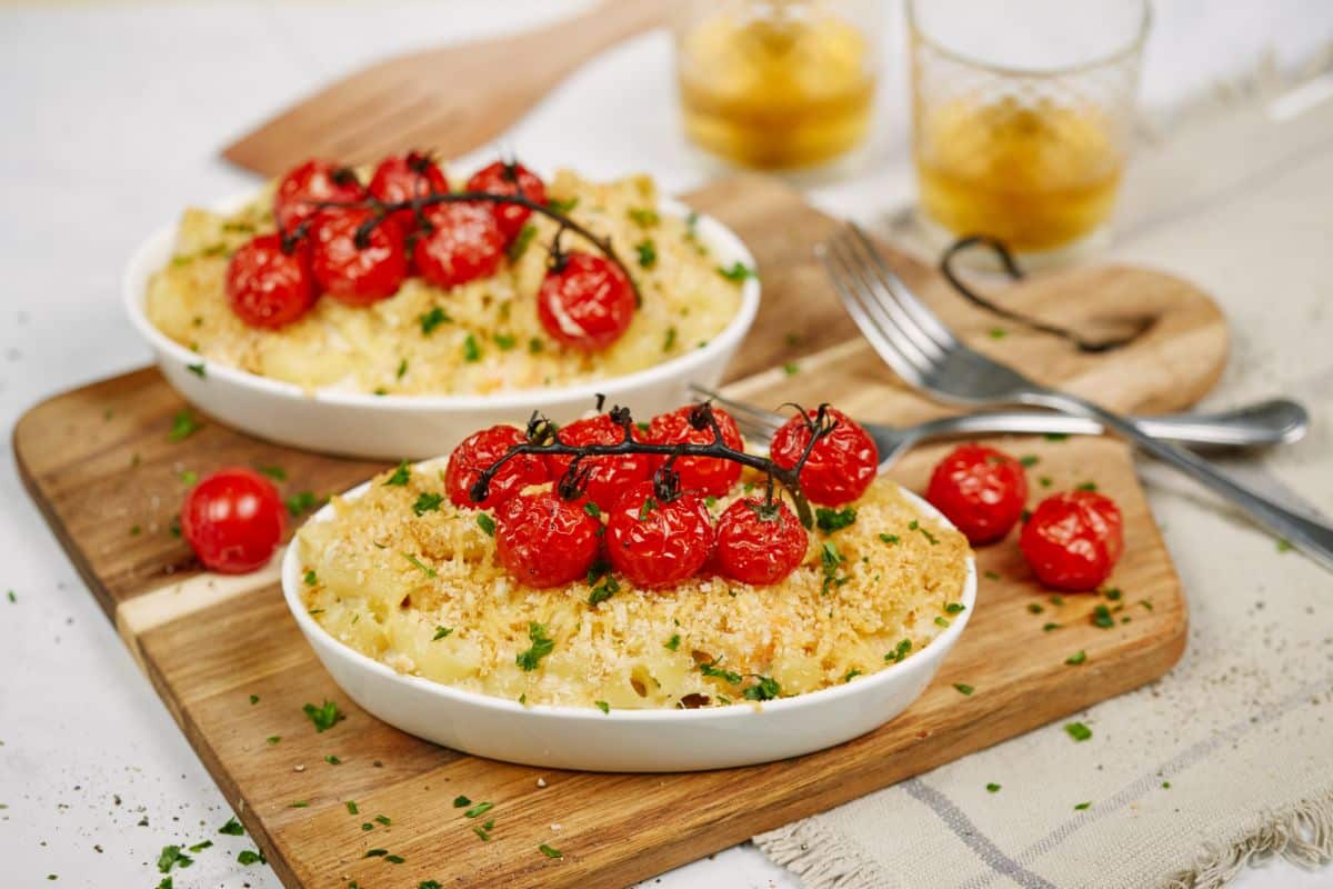 roasted cherry tomatoes on top of ramekins of pasta and shrimp casserole