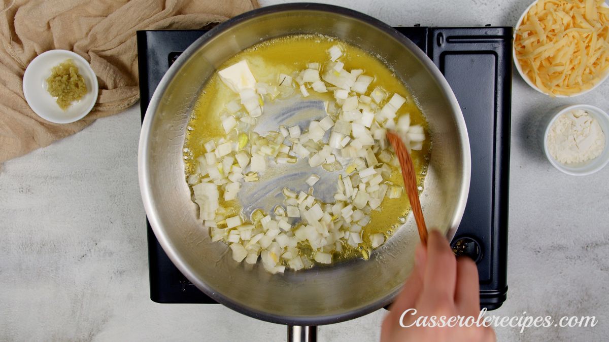 butter and onions in stainless steel skillet on hot plate