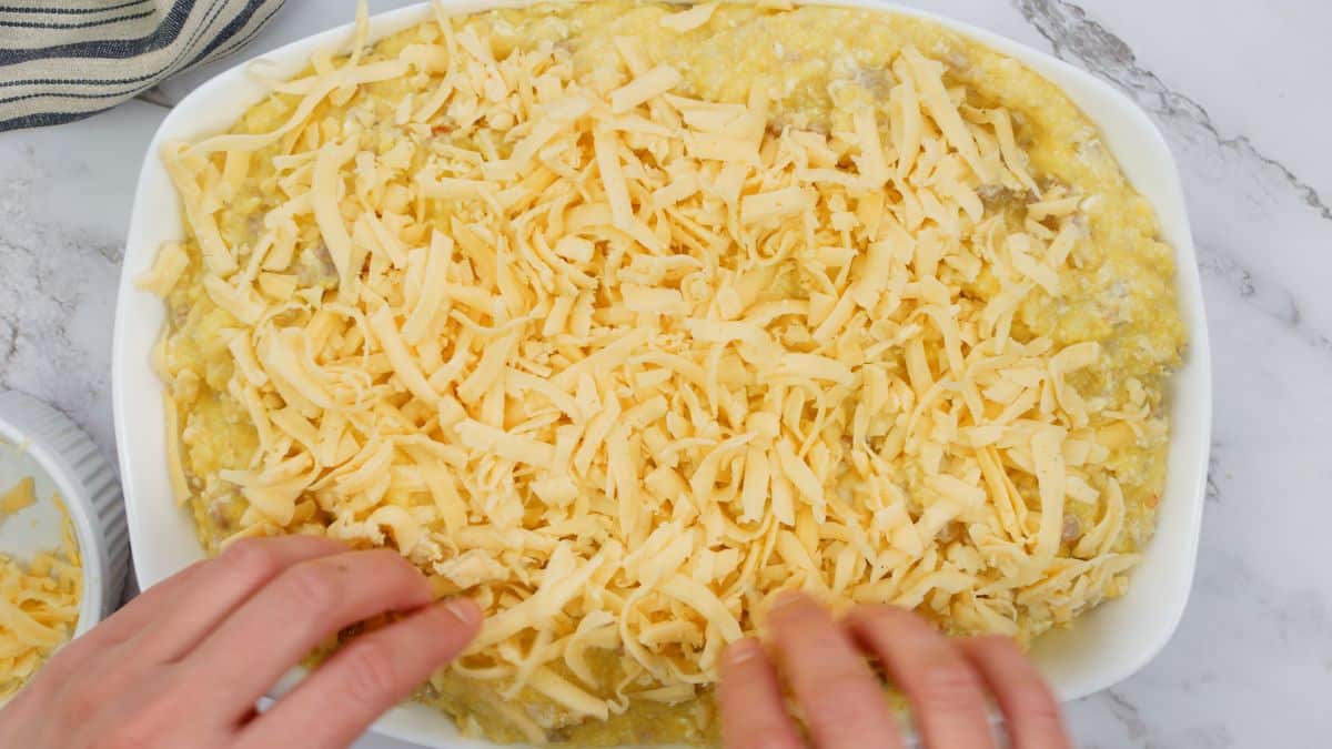 cheese being sprinkled over top of casserole