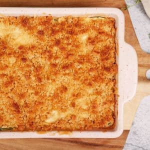 summer squash casserole with ritz cracker topping in pink baking dish