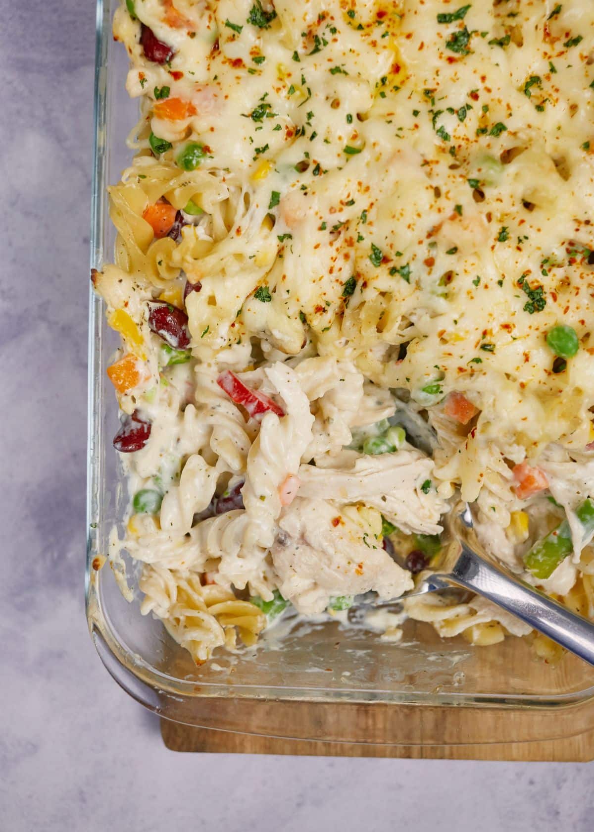 silver spoon holding portion of turkey noodle casserole above dish