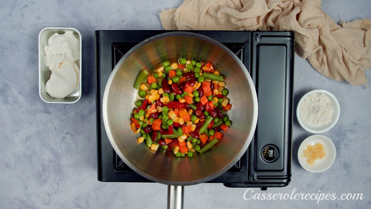 mixed vegetables in skillet on black hot plate
