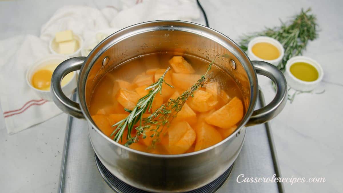 stockpot of sweet potatoes with fresh herbs