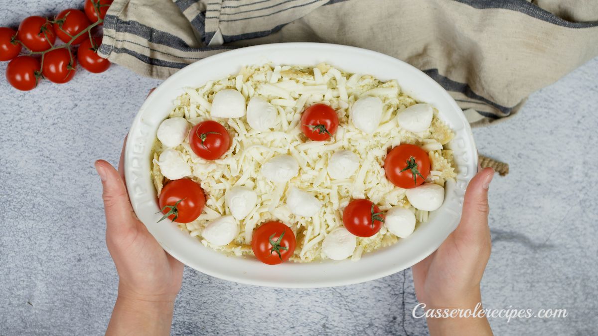 casserole topped with tomatoes and mozzarella balls before baking
