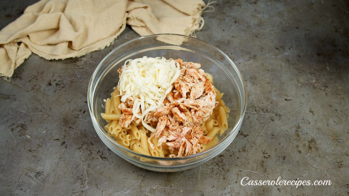 cheese and chicken added to bowl of pasta