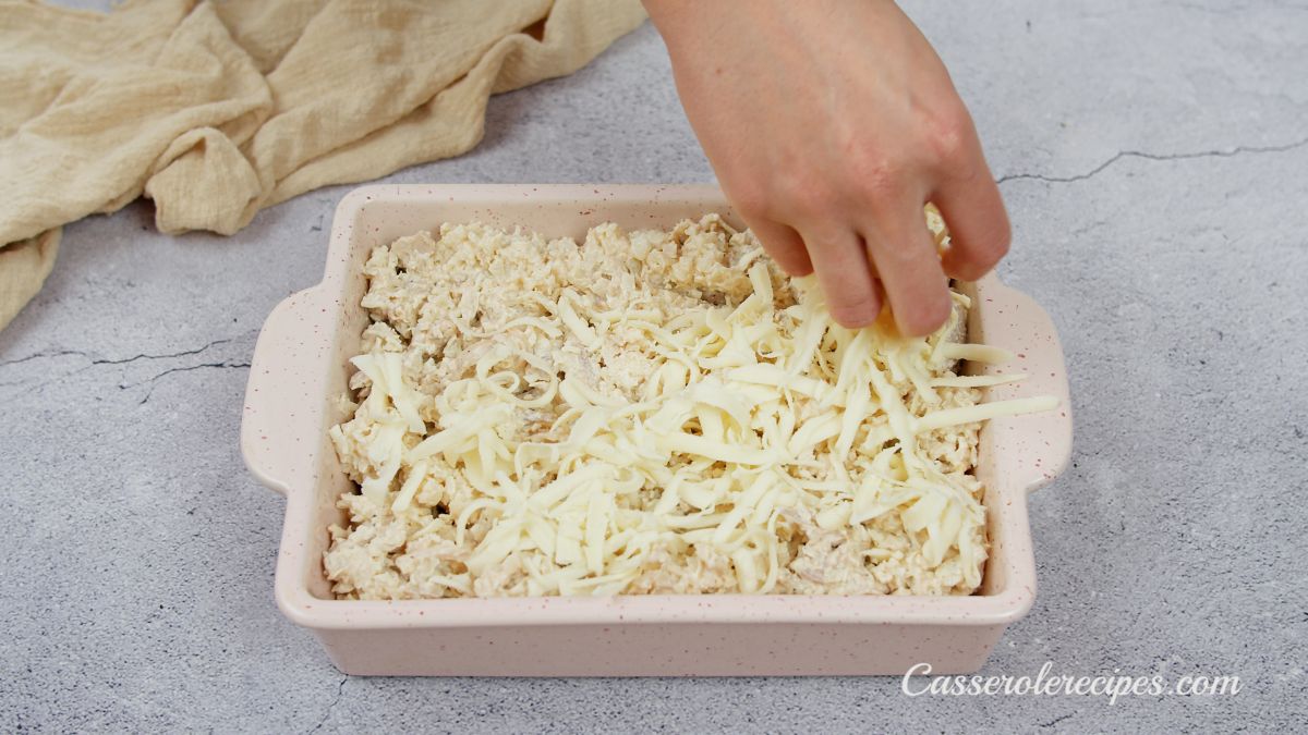 cheese being sprinkled on top of casserole