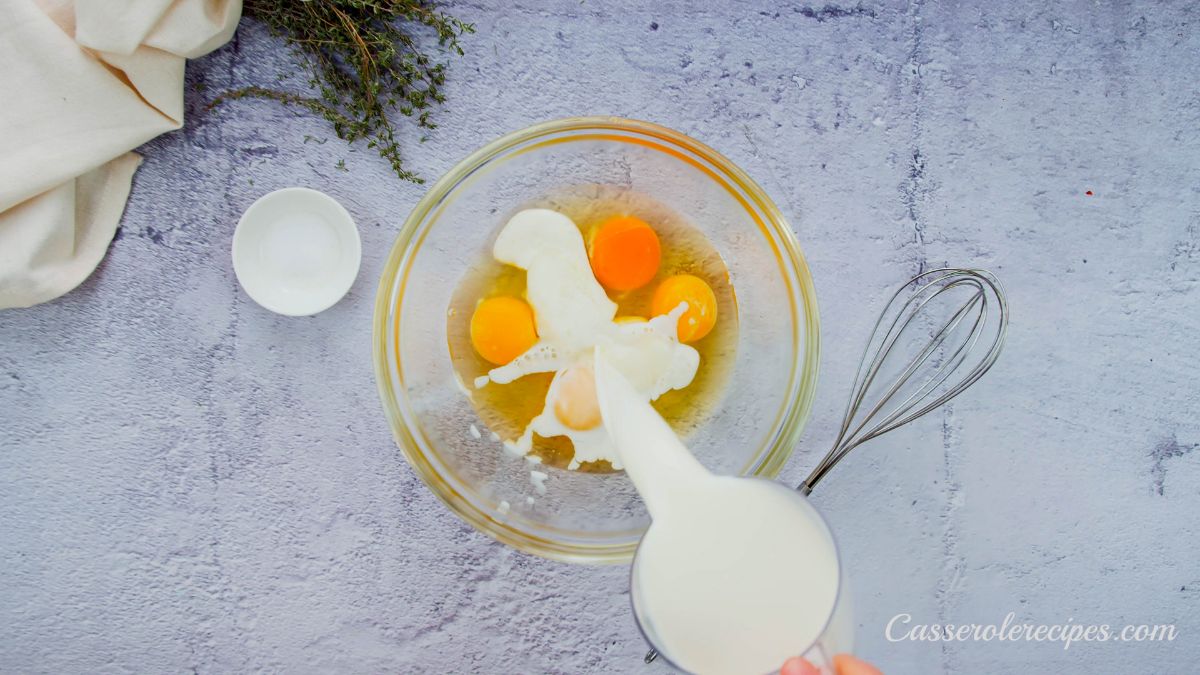 milk being poured into glass bowl with eggs