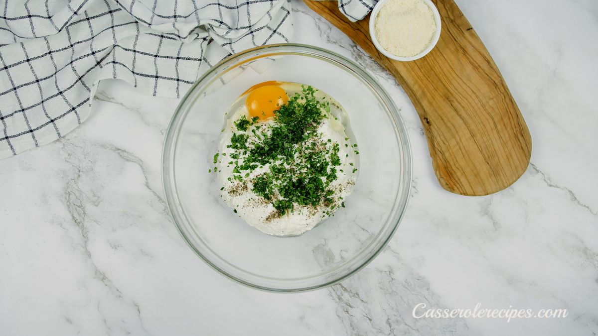 ricotta herbs and egg in glass bowl on marble table
