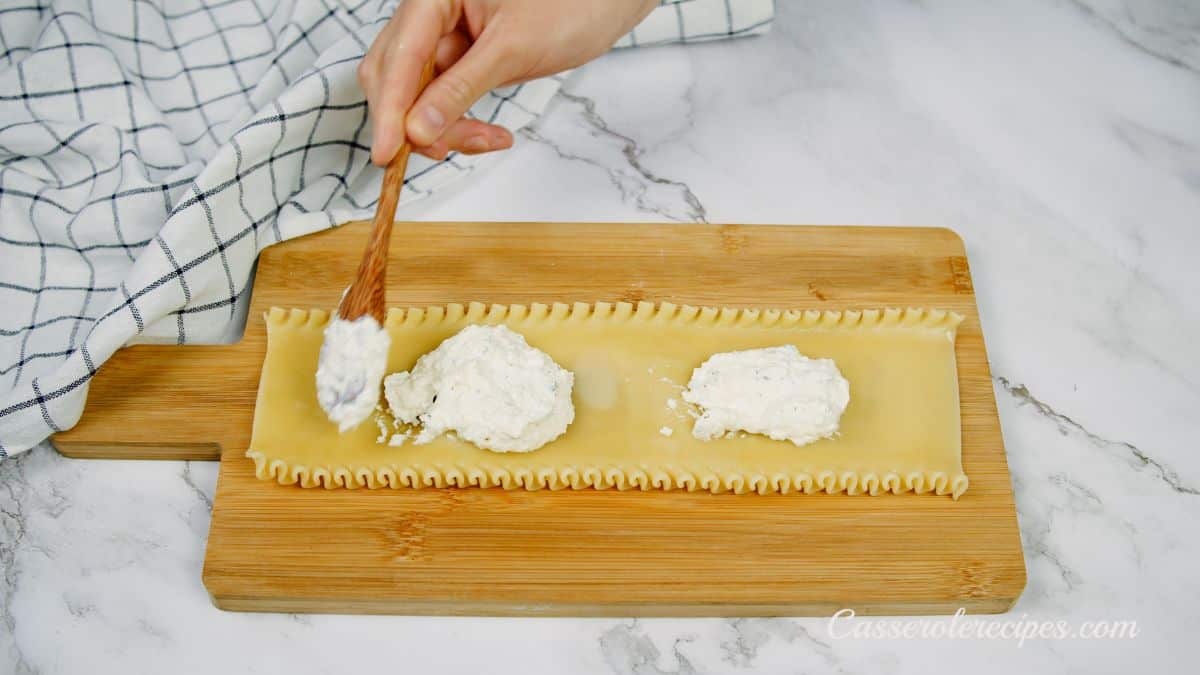 ricotta being spread on lasagna noodles