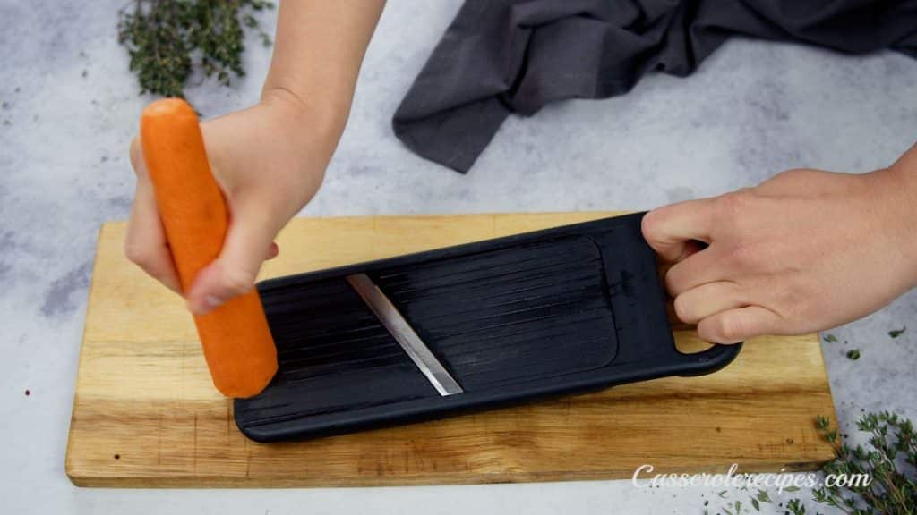 mandolin slicer being used with carrot