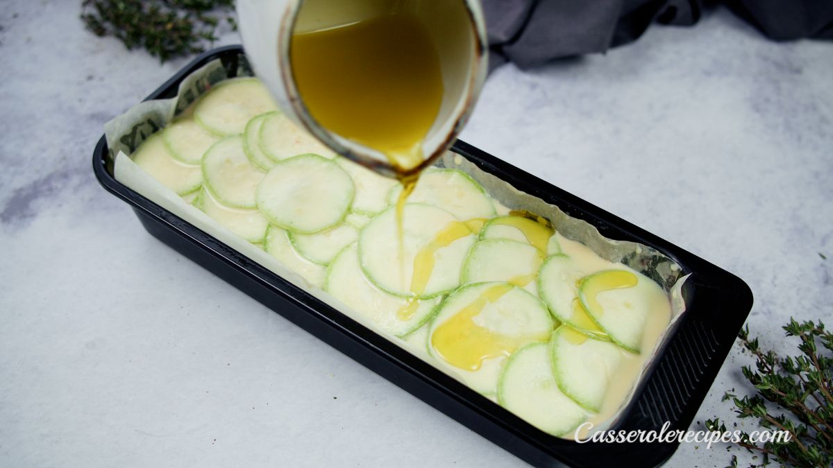 oil being poured over top of vegetable terrine before baking