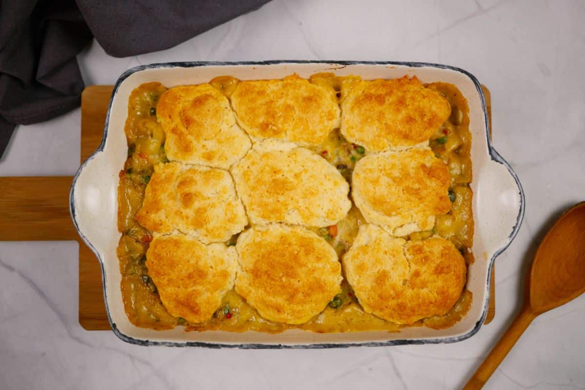 baking dish of pot pie on wooden cutting board on marble table