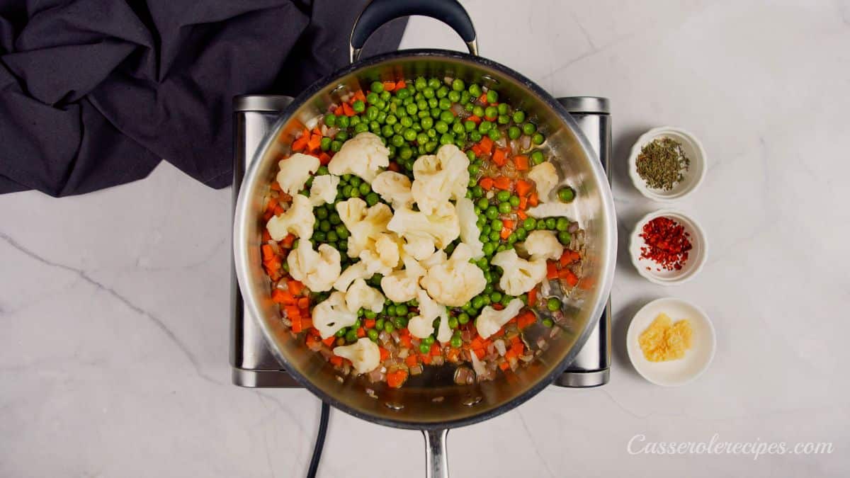 raw vegetables in saucepan on hot plate