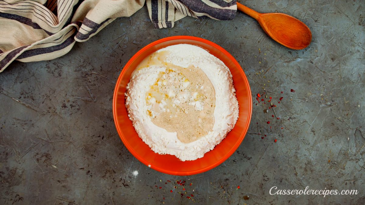 wet ingredients on top of flour in red bowl