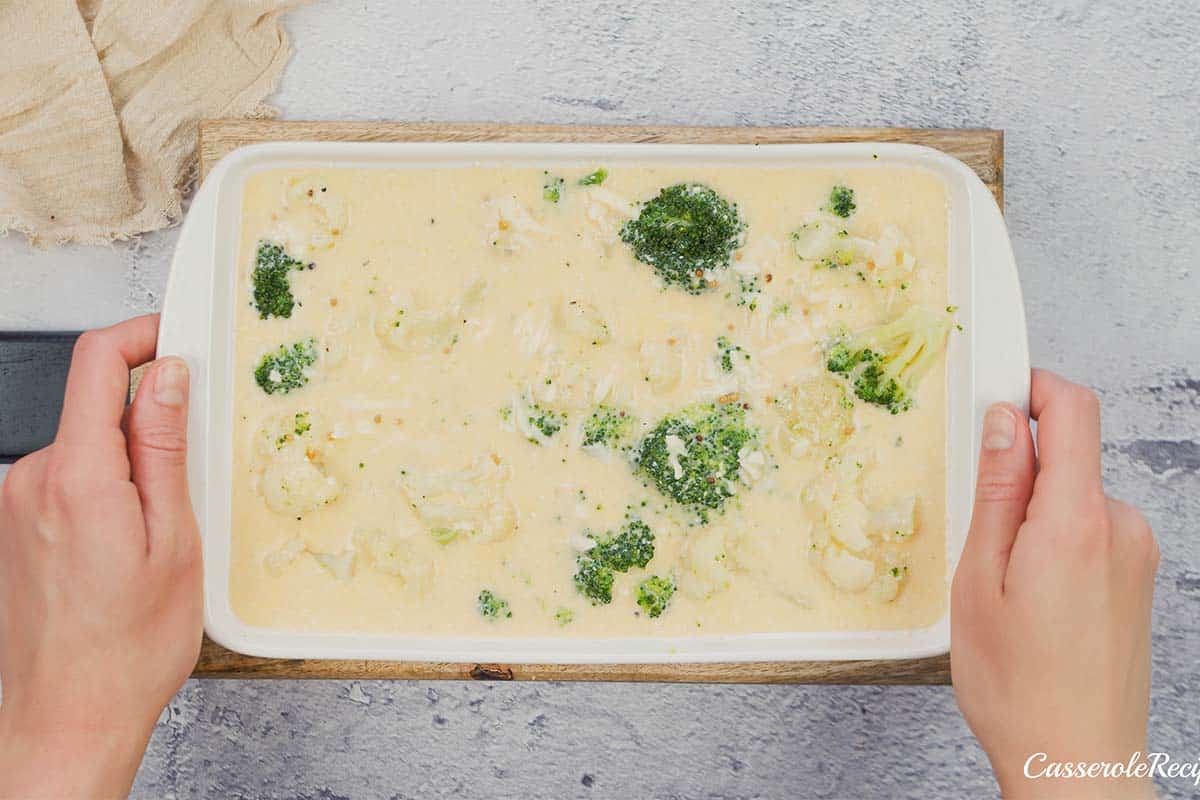 final step of making Crustless Quiche with Broccoli and Cauliflower by covering broccoli and cauliflower with egg mixture before baking