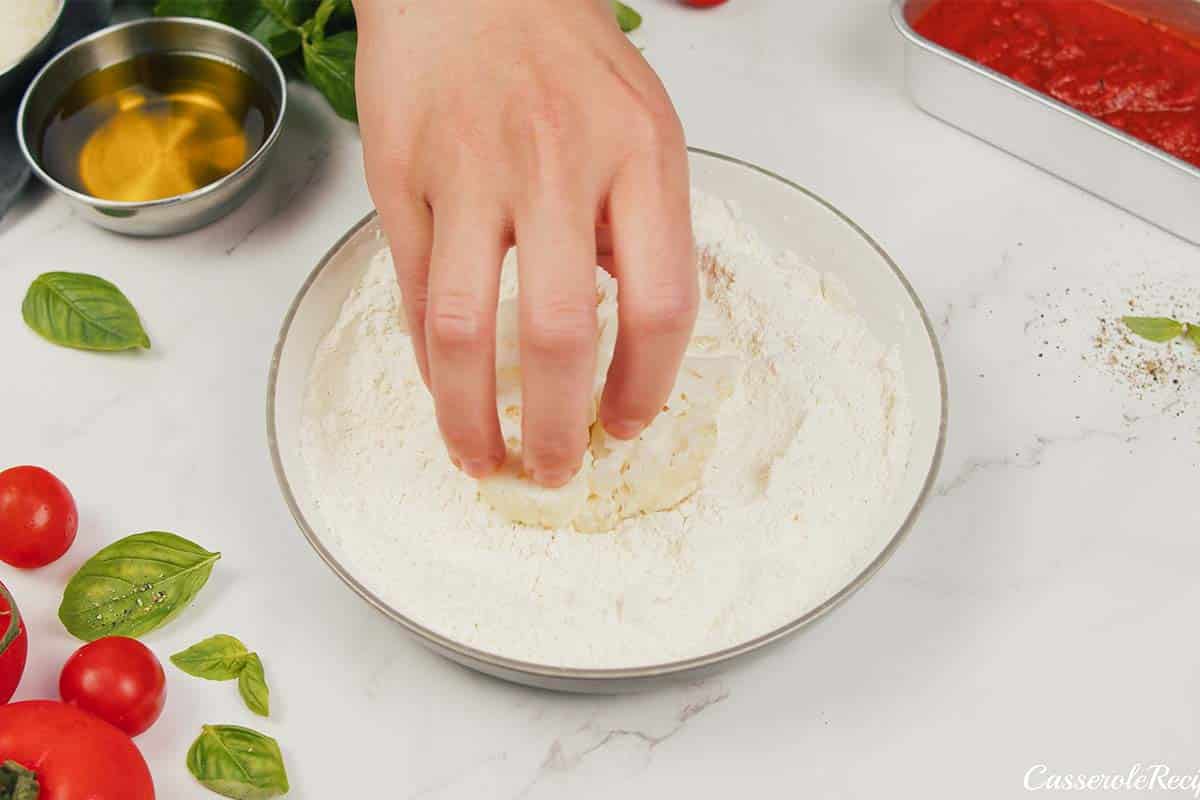 dredging cauliflower florets to make cauliflower parmesan casserole