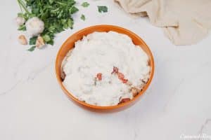 mixing ingredients in a bowl to make filling for chicken and bacon casserole