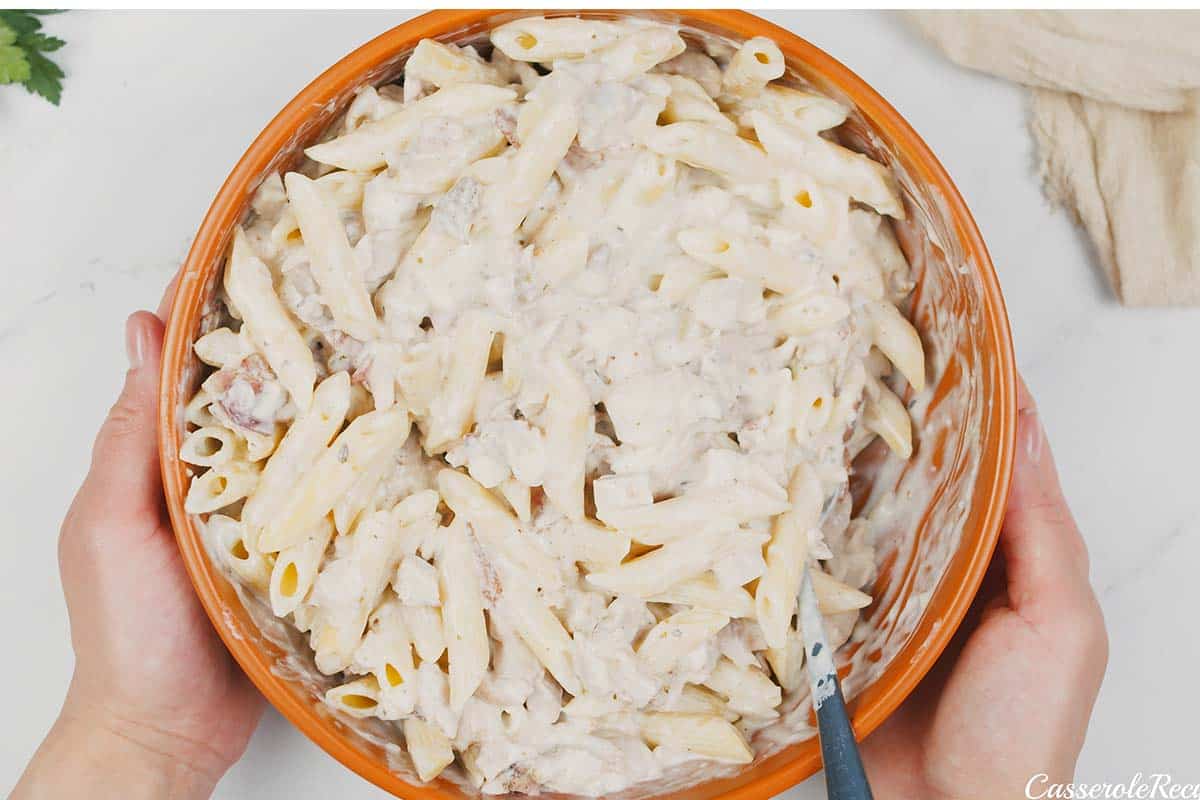 making the filling for chicken and bacon casserole by combining all of the ingredients and mixing together