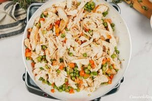 mixing together chicken and vegetables to make chicken cobbler