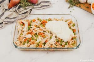 layering ingredients in a casserole dish to make the viral chicken cobbler