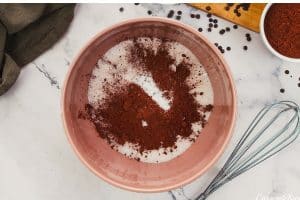 dry ingredients being added to a bowl to make chocolate cobbler