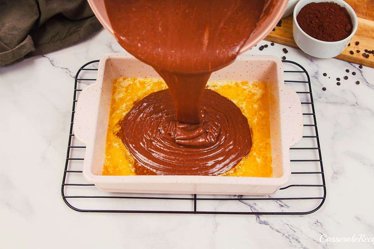 chocolate batter being poured into a baking dish to make chocolate cobbler