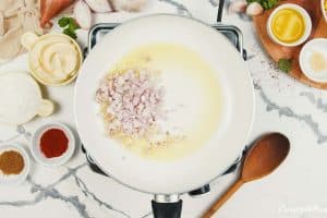 shallots being sauteed in a saucepan to make mexican street corn casserole