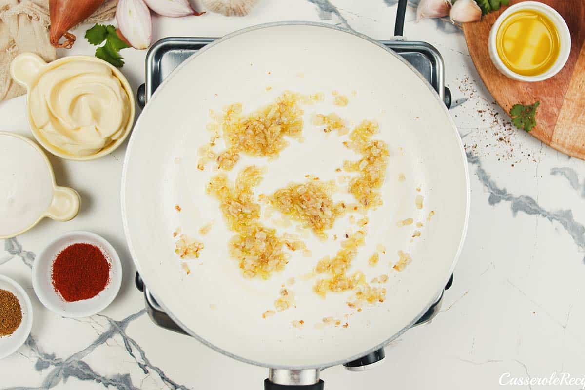 ingredients being sauted in a sauce pan to make mexican street corn casserole