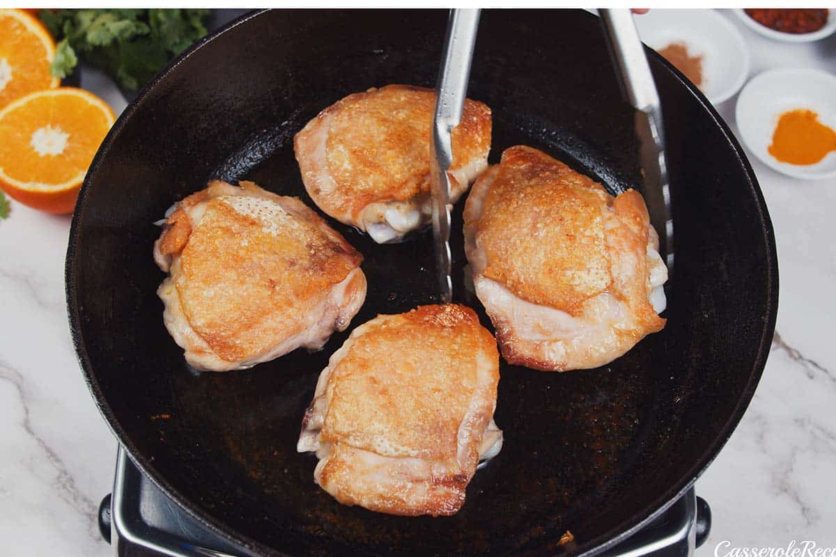 chicken thighs being cooked to make moroccan chicken casserole